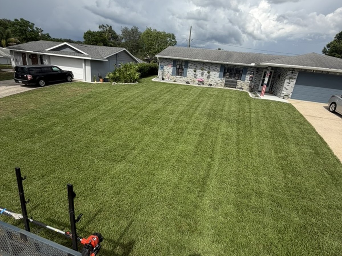 Large striped front lawn mowed and trimmed in front of a Deltona, Florida home