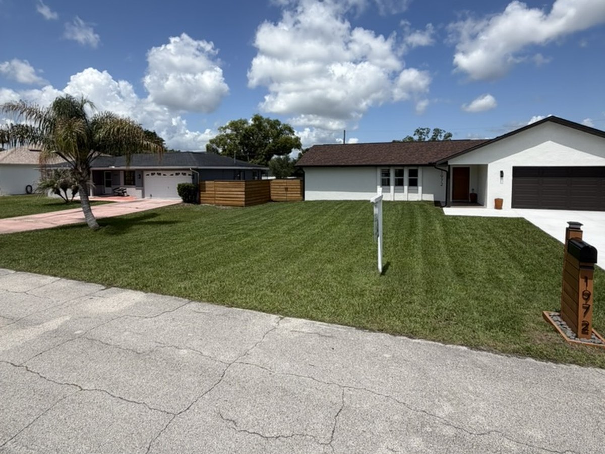 Crisply edged and striped front yard at a white house in Deltona, Florida